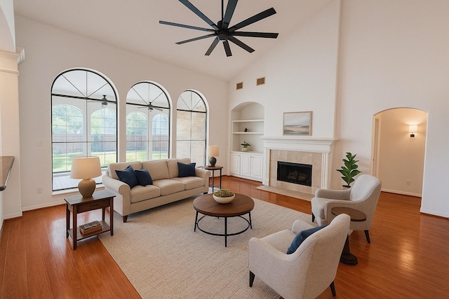 6334 Goodlowe Park, Sugar Land, TX 77479 - living room with built in shelves, high vaulted ceiling, ceiling fan, wood finished floors, and a fireplace