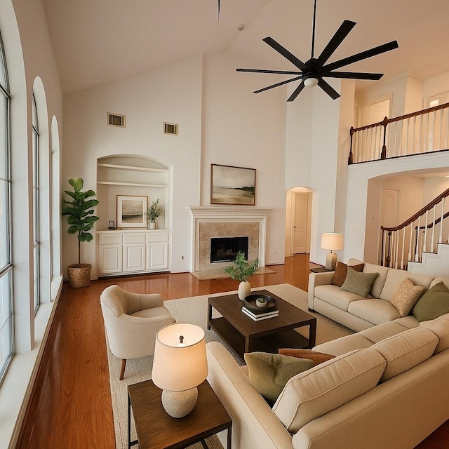 6334 Goodlowe Park, Sugar Land, TX 77479 - living area featuring high vaulted ceiling, wood finished floors, ceiling fan, stairs, and a high end fireplace
