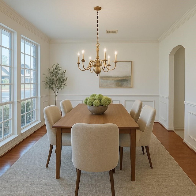 6334 Goodlowe Park, Sugar Land, TX 77479 - dining area featuring a chandelier, arched walkways, wood finished floors, ornamental molding, and a wainscoted wall
