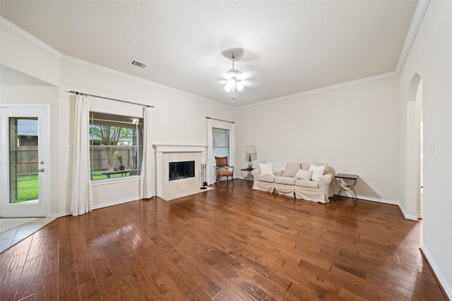 12909 Victoria Regina Dr, Montgomery, TX 77356 - living area with arched walkways, ceiling fan, hardwood / wood-style flooring, crown molding, and a tiled fireplace