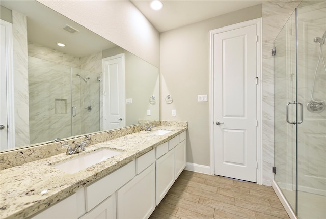 5502 Camaguey St, Houston, TX 77023 - full bathroom with a stall shower, baseboards, wood finish floors, double vanity, and recessed lighting