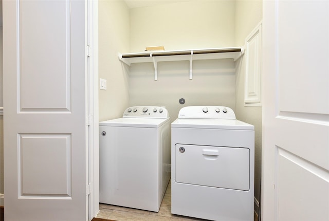 5502 Camaguey St, Houston, TX 77023 - laundry area featuring washing machine and clothes dryer and light wood-style floors
