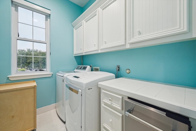 13839 Windlass Cir, Galveston, TX 77554 - laundry area featuring cabinet space, washer and dryer, baseboards, and tile patterned floors