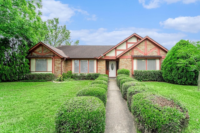 1618 Monroe Dr, Deer Park, TX 77536 - tudor-style house featuring a front yard, a shingled roof, and brick siding