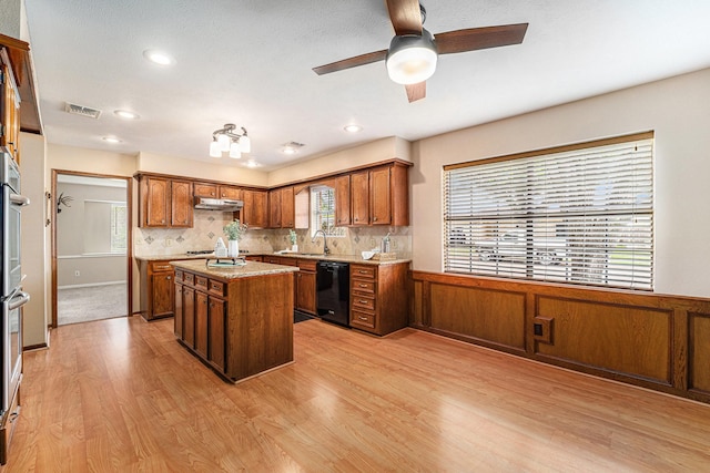 1618 Monroe Dr, Deer Park, TX 77536 - kitchen with dishwasher, under cabinet range hood, light wood-style floors, a sink, and a kitchen island