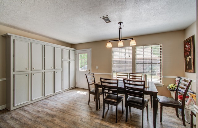 2915 Quailwood St, Houston, TX 77014 - dining room with light wood-type flooring, a textured ceiling, and baseboards