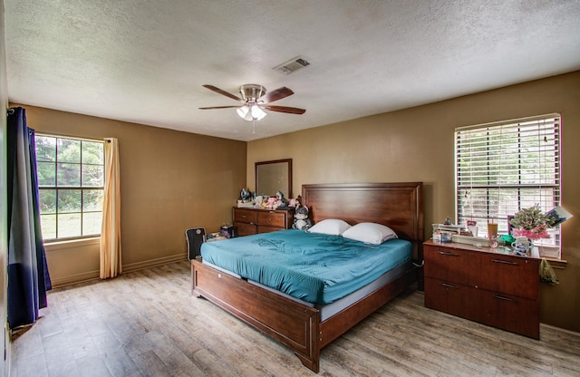 2915 Quailwood St, Houston, TX 77014 - bedroom featuring light wood finished floors, a textured ceiling, baseboards, and ceiling fan