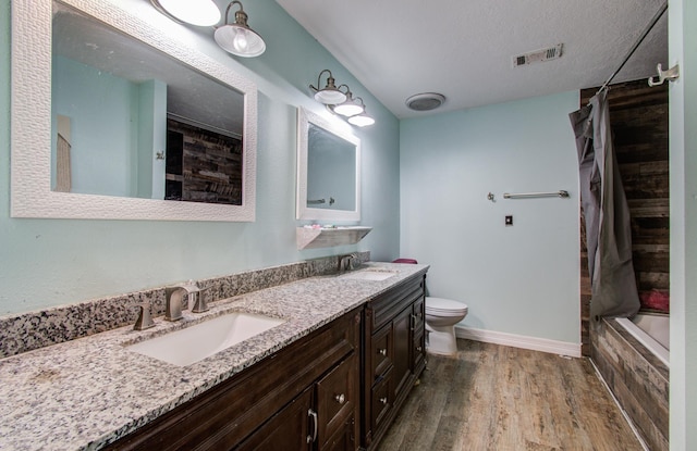 2915 Quailwood St, Houston, TX 77014 - bathroom with wood finished floors, toilet, double vanity, and baseboards