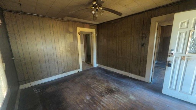 1111 Austin St, Jacksonville, TX 75766 - empty room featuring wood walls, ceiling fan, baseboards, and wood finished floors