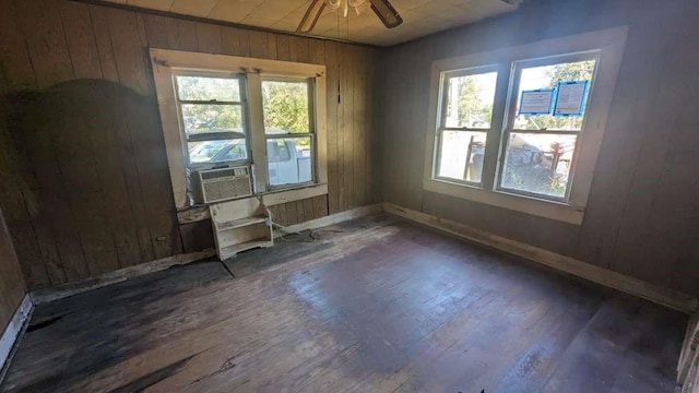 1111 Austin St, Jacksonville, TX 75766 - spare room featuring wood-type flooring, plenty of natural light, wood walls, baseboards, and ceiling fan