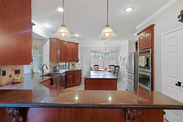 12915 Birch Falls Rd, Houston, TX 77065 - kitchen with appliances with stainless steel finishes, a kitchen island, crown molding, backsplash, and a chandelier