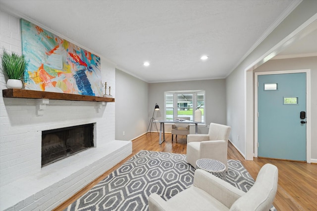 living room with baseboards, crown molding, wood finished floors, recessed lighting, and a fireplace