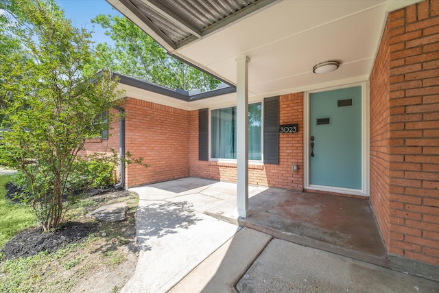 doorway to property featuring brick siding