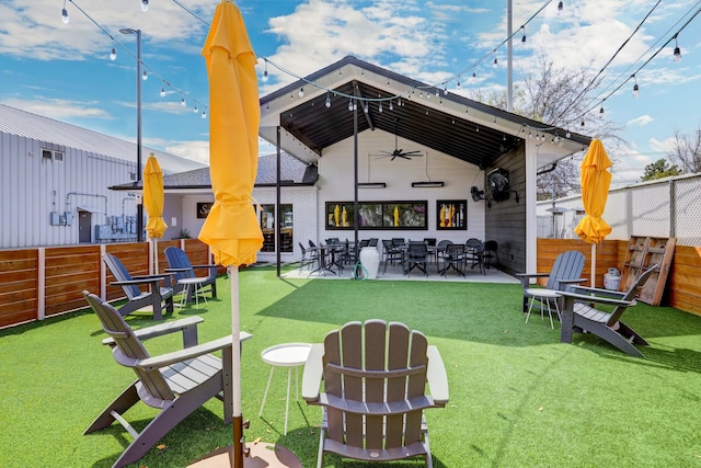 rear view of property featuring a ceiling fan and a patio
