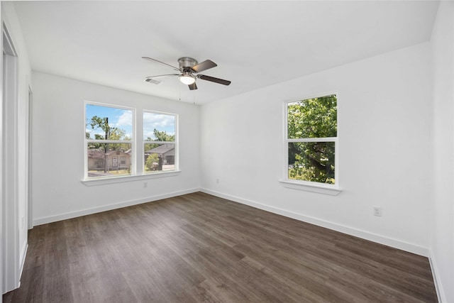 empty room with dark wood-style floors, ceiling fan, and baseboards