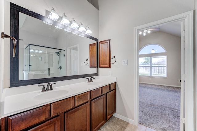 8246 Mandalay Bay Dr, Baytown, TX 77523 - bathroom featuring ceiling fan, a stall shower, double vanity, vaulted ceiling, and baseboards