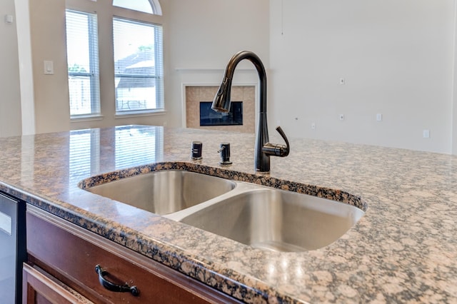 8246 Mandalay Bay Dr, Baytown, TX 77523 - kitchen view of a sink, a tiled fireplace, and dark stone countertops