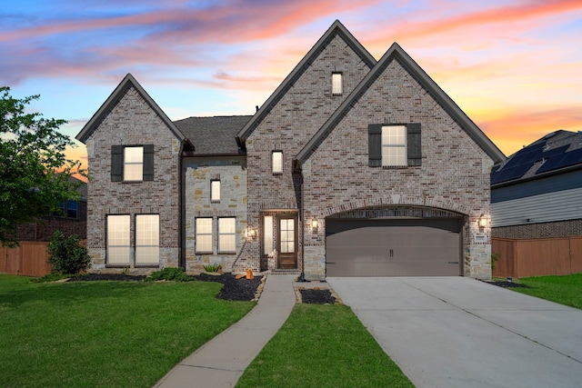 french country home with concrete driveway, a garage, and brick siding
