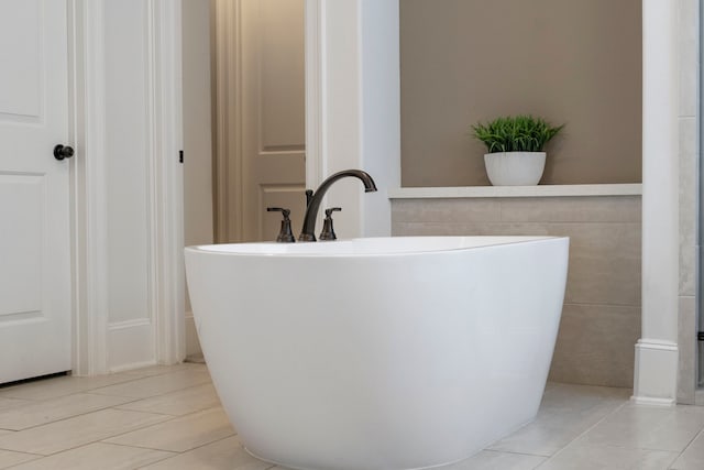 bathroom with tile patterned flooring and a freestanding tub