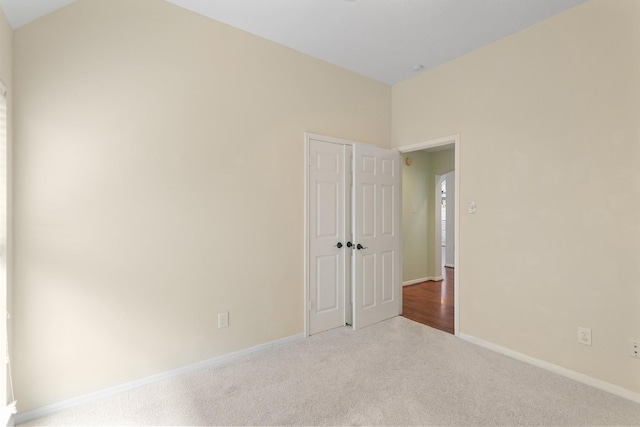 empty room featuring carpet floors and baseboards