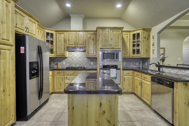 kitchen featuring appliances with stainless steel finishes, a sink, lofted ceiling, under cabinet range hood, and a center island
