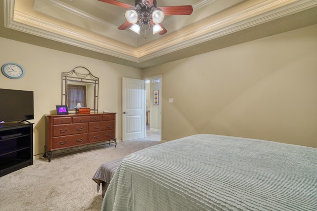 bedroom with a tray ceiling, light colored carpet, ornamental molding, and a ceiling fan