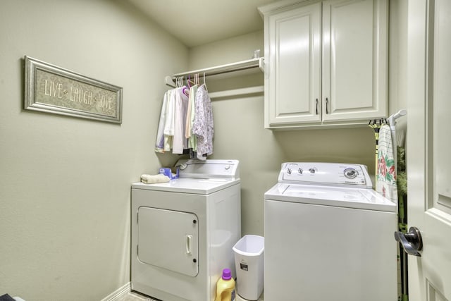 clothes washing area featuring washer and clothes dryer and cabinet space
