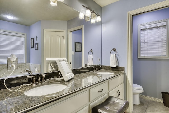 full bathroom featuring tile patterned flooring, double vanity, toilet, and baseboards