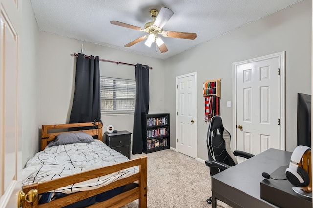 carpeted bedroom with a desk, a textured ceiling, ceiling fan, and baseboards