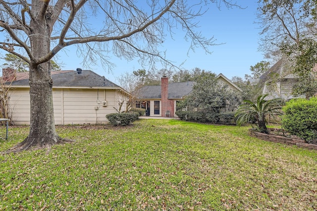 back of property featuring a yard and a chimney