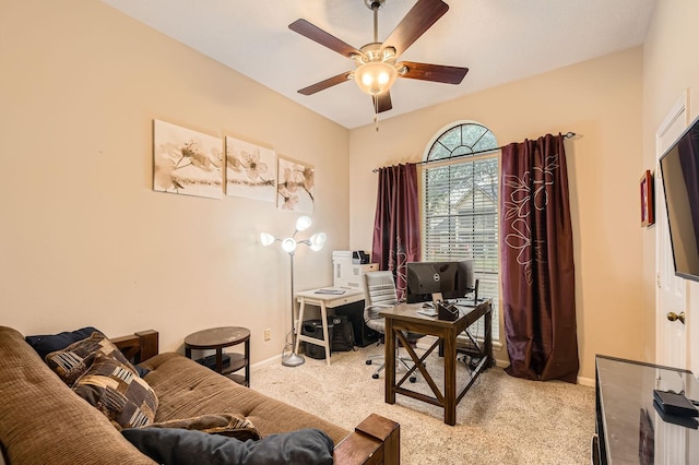 carpeted office space featuring ceiling fan and baseboards
