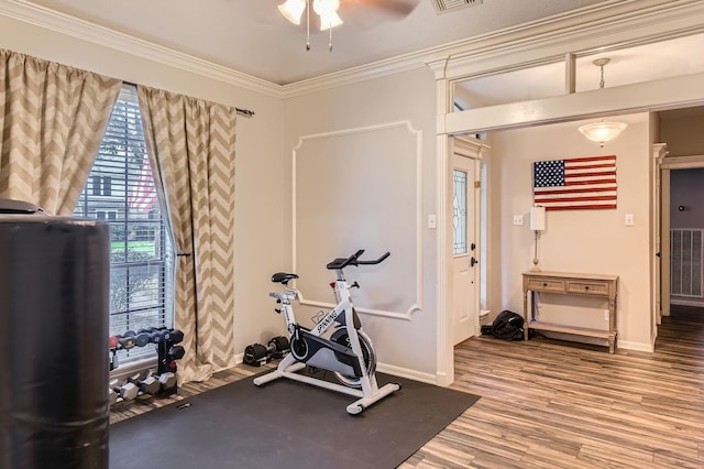workout area with baseboards, crown molding, wood finished floors, and ceiling fan