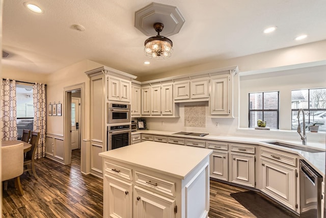 kitchen featuring a sink, stainless steel appliances, dark wood-style flooring, light countertops, and recessed lighting