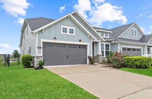 18127 Shoreline Vista Ln, Cypress, TX 77433 - view of front facade with stone siding, driveway, and board and batten siding