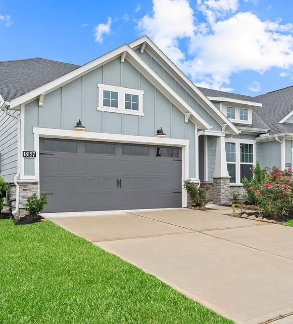 18127 Shoreline Vista Ln, Cypress, TX 77433 - view of front of house featuring stone siding, an attached garage, driveway, and roof with shingles