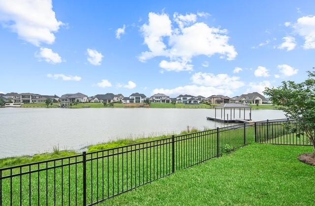 18127 Shoreline Vista Ln, Cypress, TX 77433 - water view featuring a dock, nearby suburban area, and fence