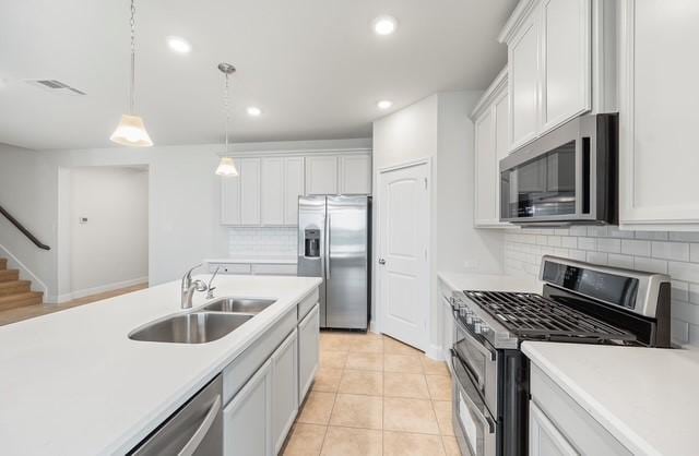 18127 Shoreline Vista Ln, Cypress, TX 77433 - kitchen featuring stainless steel appliances, a sink, decorative backsplash, light countertops, and recessed lighting