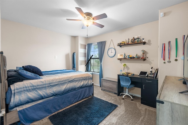 bedroom with light colored carpet, an office area, a ceiling fan, and baseboards