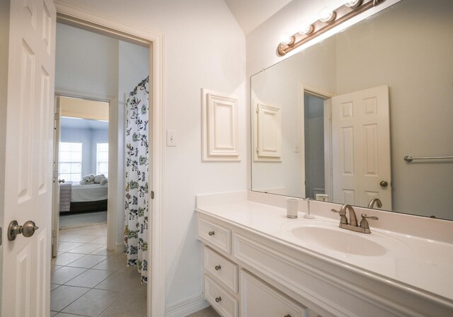 full bath with tile patterned flooring, vanity, and baseboards