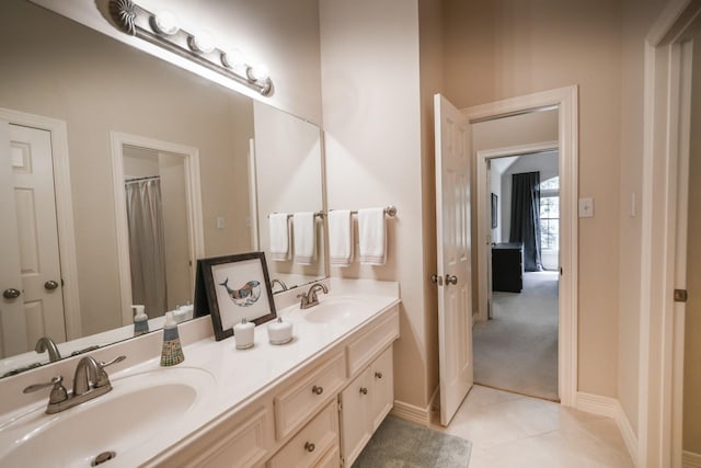 bathroom featuring double vanity, baseboards, and tile patterned flooring