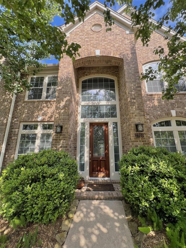 property entrance featuring brick siding