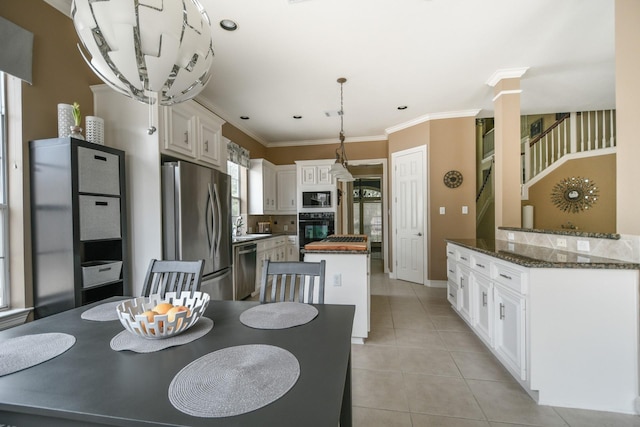 dining room with ornate columns, light tile patterned floors, crown molding, and baseboards