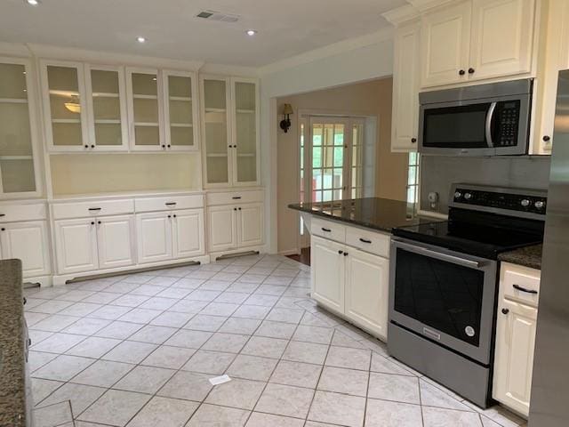kitchen with stainless steel appliances, white cabinets, light tile patterned flooring, glass insert cabinets, and recessed lighting