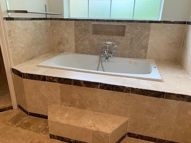 bathroom featuring healthy amount of natural light and a garden tub