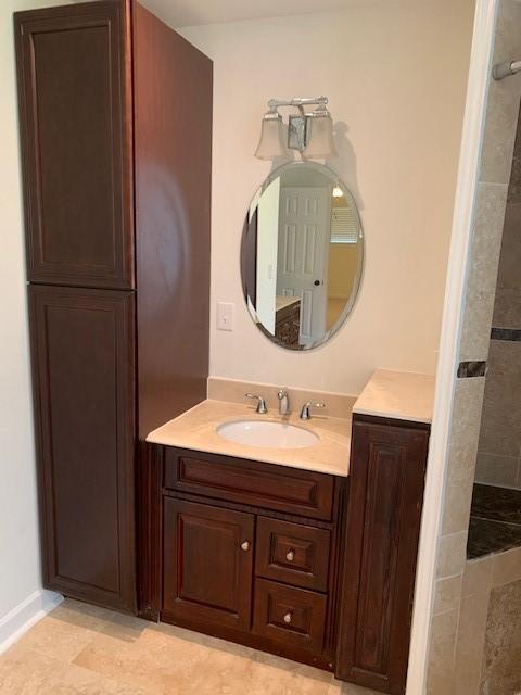 full bathroom featuring vanity and tiled shower