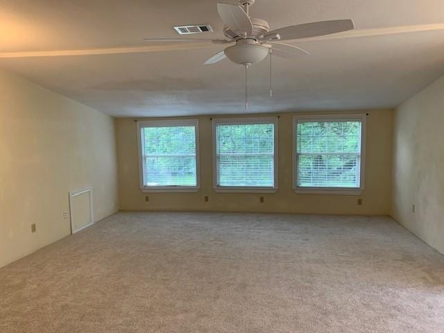 carpeted empty room with a ceiling fan