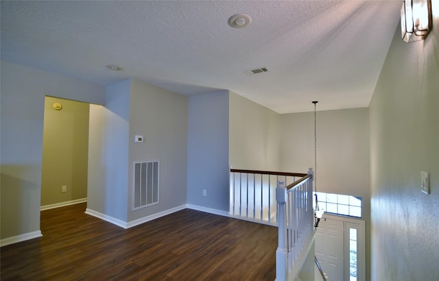 18411 Arrow Flint Cv, Houston, TX 77084 - hall with dark wood-type flooring, baseboards, a textured ceiling, a chandelier, and an upstairs landing