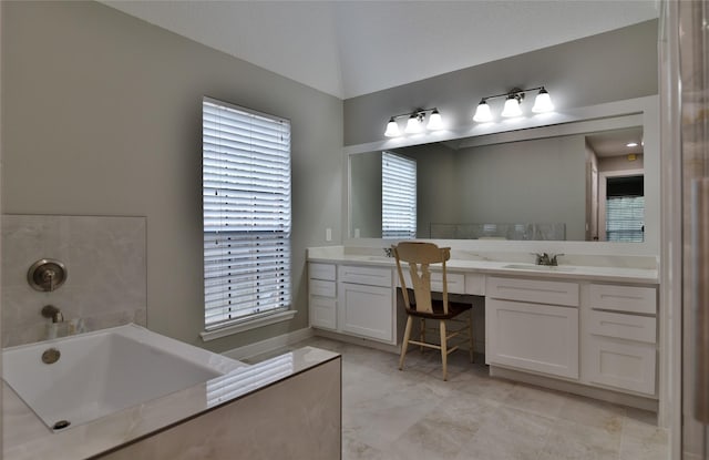 18411 Arrow Flint Cv, Houston, TX 77084 - bathroom featuring two vanities, a garden tub, and healthy amount of natural light