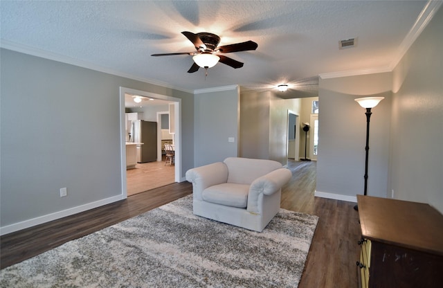 18411 Arrow Flint Cv, Houston, TX 77084 - living area featuring ceiling fan, wood finished floors, crown molding, baseboards, and a textured ceiling