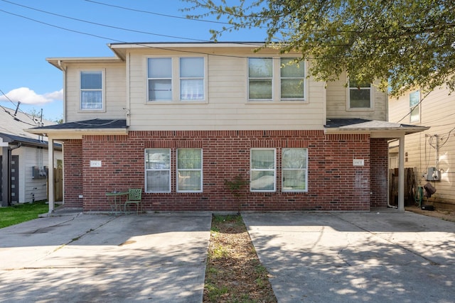 view of front of property with brick siding and a patio area